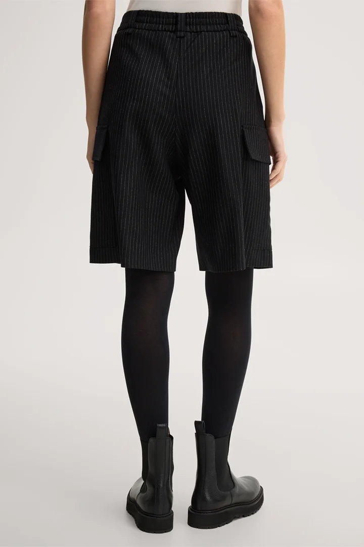 Mène à la page produit « Short en laine vierge à fines rayures, avec poches cargo, noir »