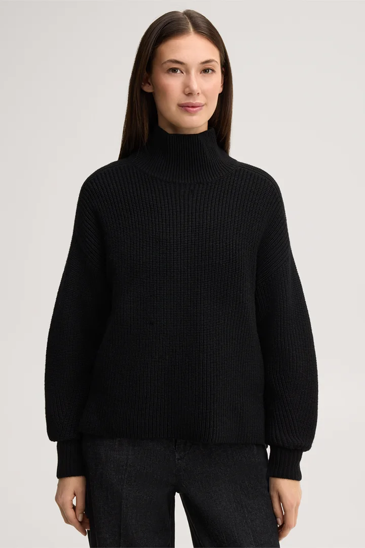 Leads to product detail page "Black merino wool jumper with a stand-up collar"