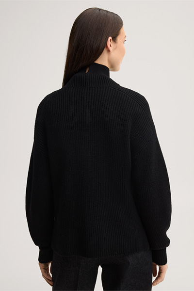 Leads to product detail page "Black merino wool jumper with a stand-up collar"