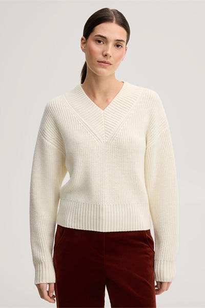 Leads to product detail page "Ecru merino knit jumper with a V-neck"