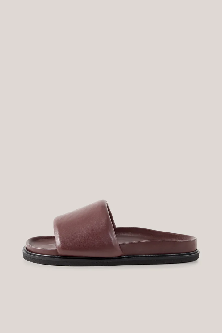 Leads to product detail page "Slides in lamb nappa leather in plum"
