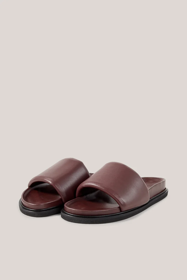 Leads to product detail page "Slides in lamb nappa leather in plum"